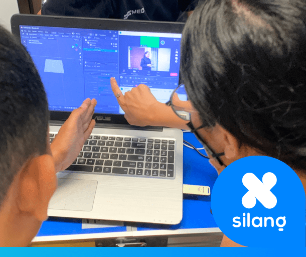 Pelatih sedang mengajarkan peserta di depan laptop pada acara silang empowerment